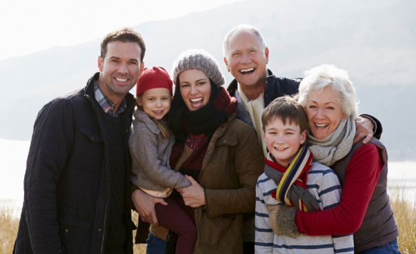 Three generations of a family smiling together outdoors