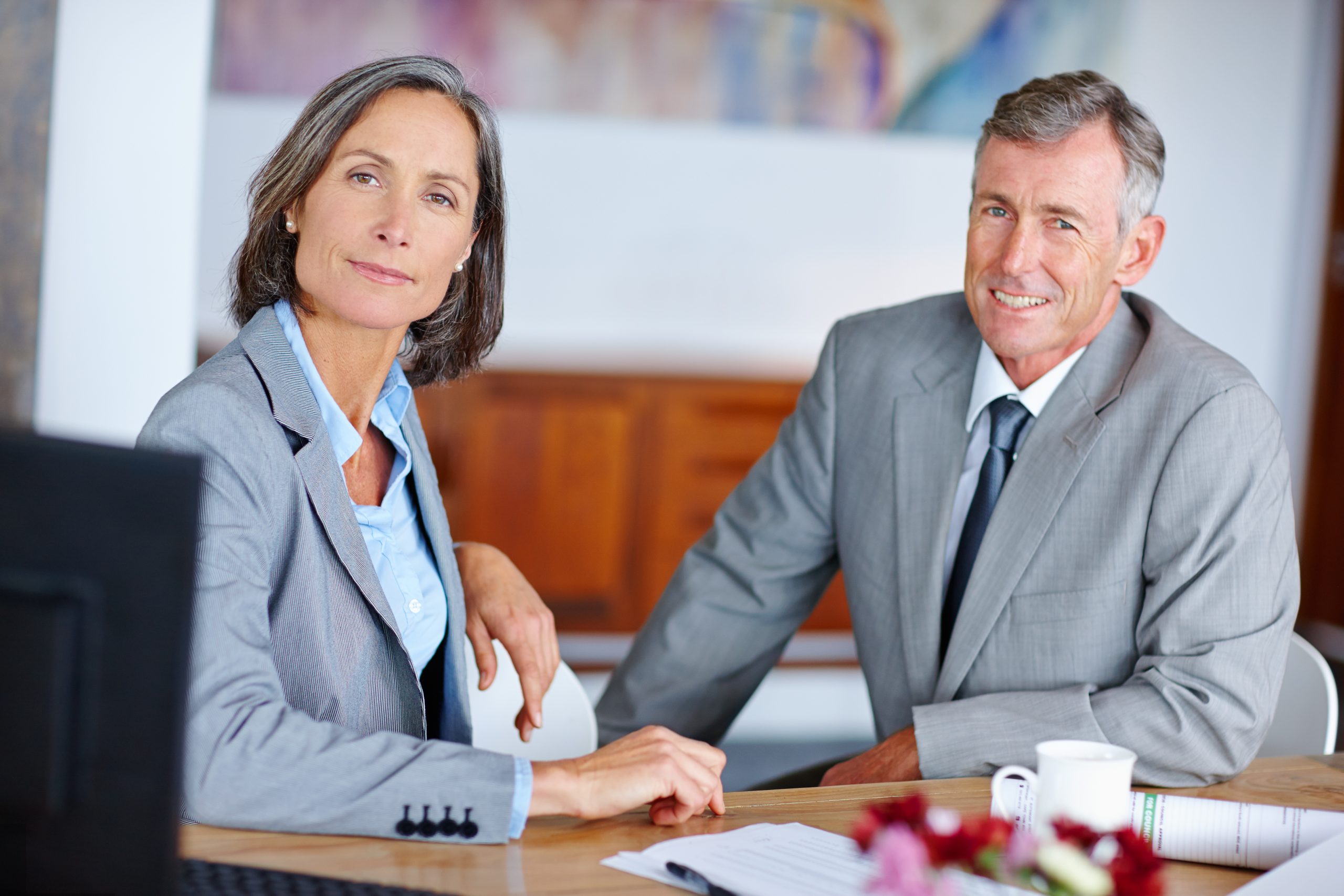 Two business executives standing in an office boardroom setting